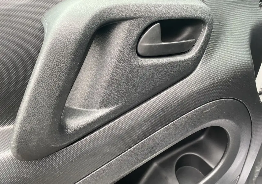 Gros plan sur la poignée intérieure de porte noire du Citroën Berlingo blanc, version Van M BlueHDi 2018.
