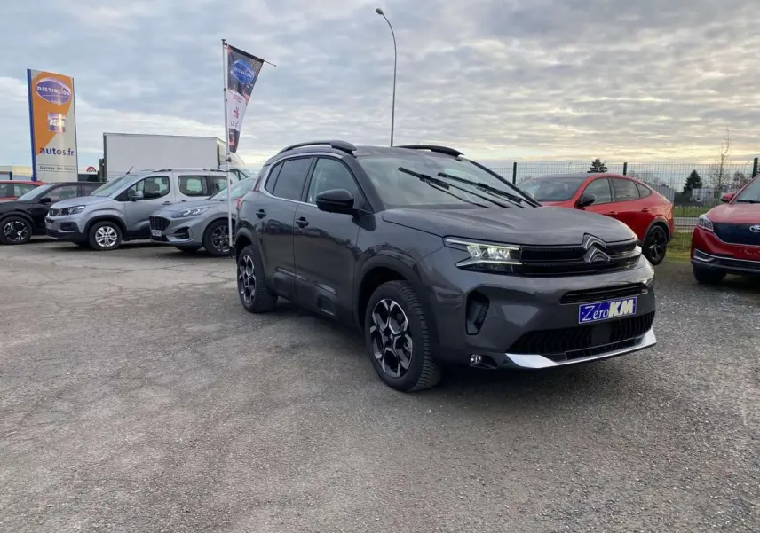 Citroën C5 Aircross gris platinium en 3/4 avant droit, avec jantes alliage bi-ton et projecteurs LED allumés.