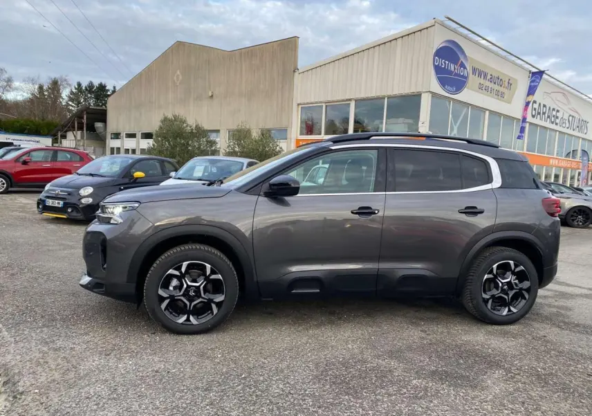 Vue de profil côté gauche d’un Citroën C5 Aircross 2025 gris platinium avec jantes alliage noires et toit noir.