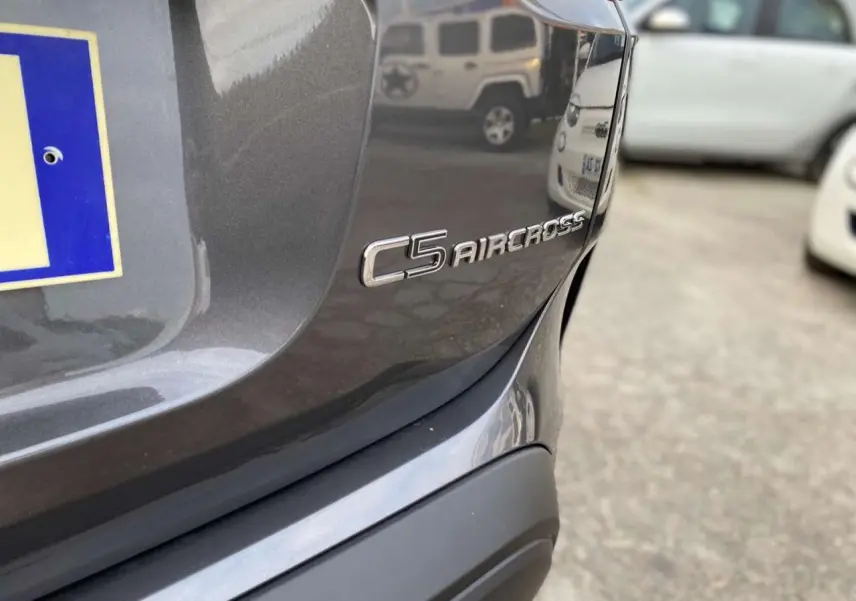 Gros plan sur l'arrière droit gris platinium du Citroën C5 Aircross avec le logo du modèle visible.