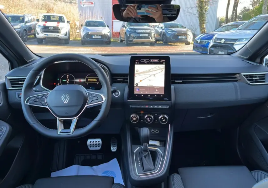 Vue intérieure avant de la Renault Clio V E-Tech 145 Esprit Alpine 2025, avec tableau de bord numérique et écran tactile central.