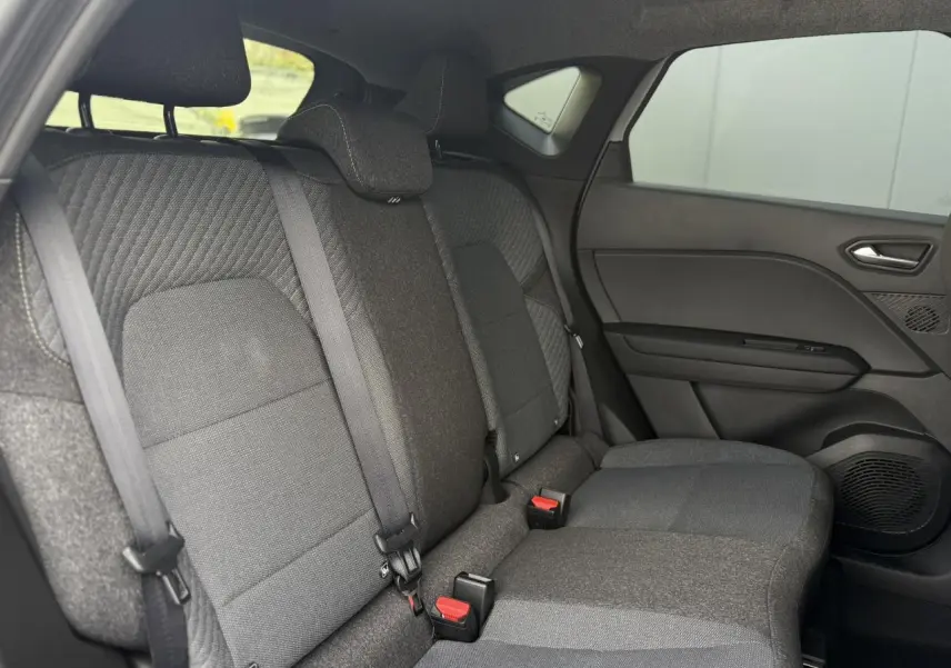 Vue intérieure côté droit des sièges arrière gris foncé du Renault Captur 2026 avec ceintures et appuie-têtes intégrés.