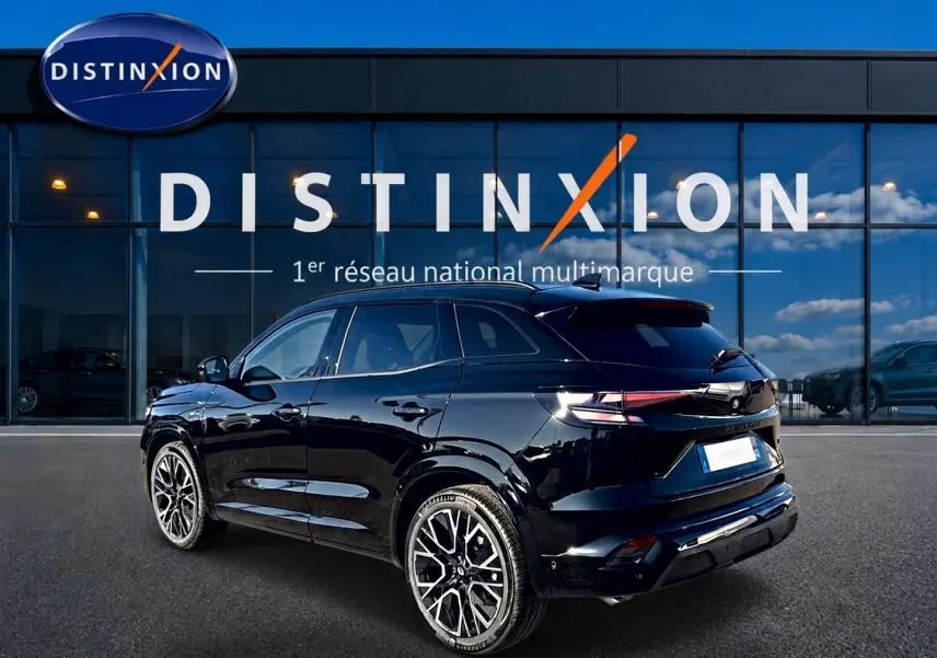 Renault Austral noir en 3/4 arrière droit, avec jantes alu distinctives et feux arrière LED allumés.