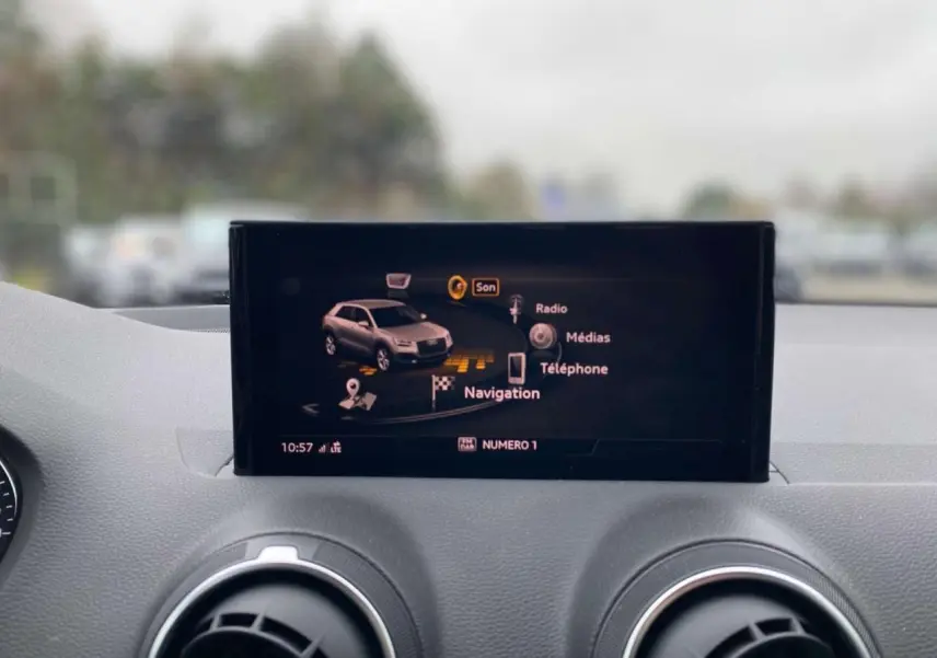 Écran central de navigation Audi Q2 2023 affichant les options son, radio, médias et téléphone, intérieur gris.