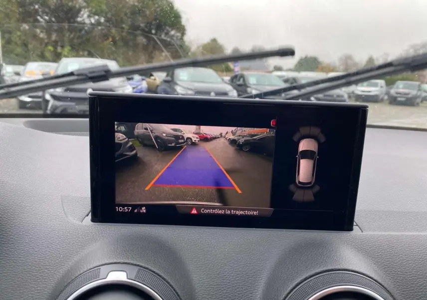 Vue intérieure du tableau de bord de l'Audi Q2 noir 2023, écran caméra de recul avec guidage de trajectoire visible.