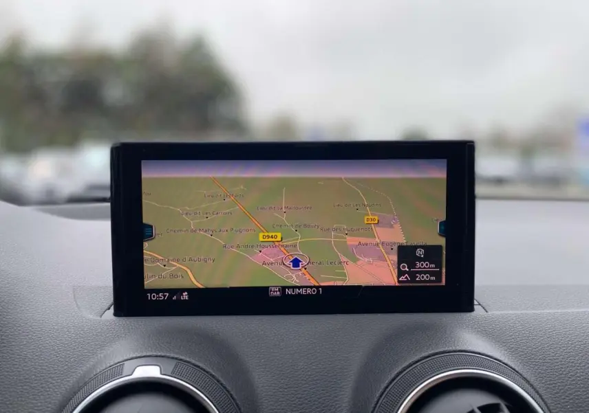 Vue rapprochée de l’écran de navigation MMI sur le tableau de bord de l’Audi Q2 noir, affichant une carte détaillée.