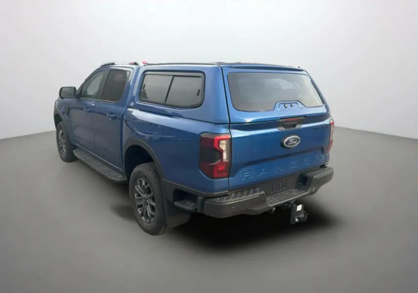 Ford Ranger 3.0 V6 Wildtrak bleu lightning vu de l'arrière droit avec hard-top vitré et attelage.