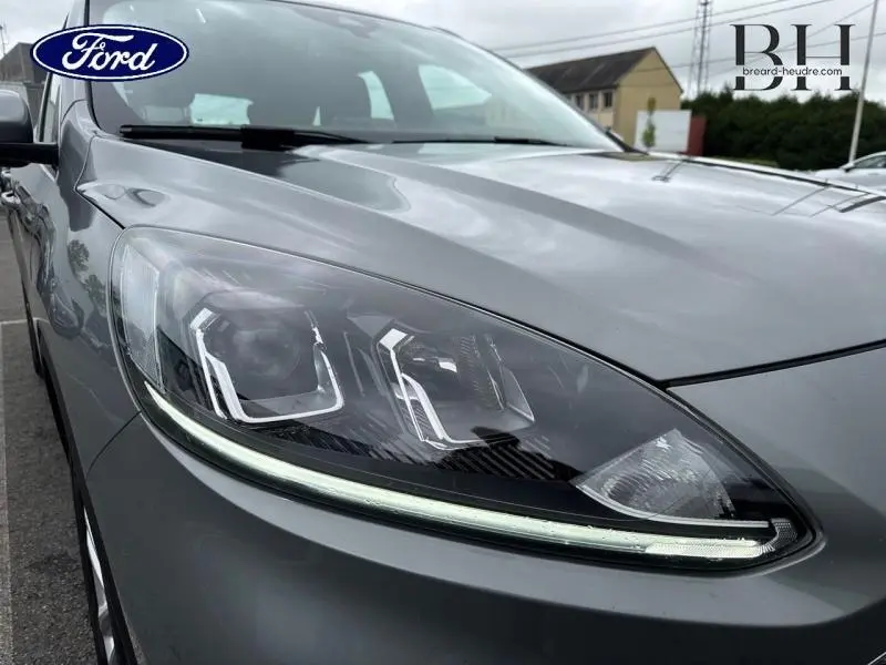 Gros plan sur le phare avant gauche du Ford Kuga 2023 gris Solar Métallisé avec signature lumineuse LED.