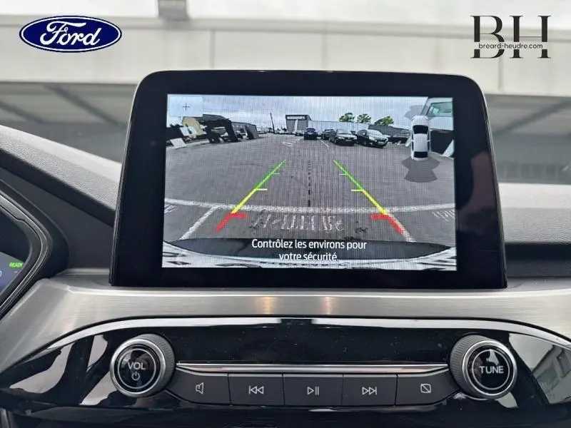 Écran tactile central montrant la caméra de recul d'un Ford Kuga gris Solar, vue intérieure avant du tableau de bord.