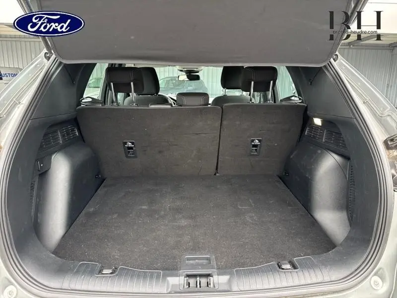 Coffre ouvert vu de l'arrière du Ford Kuga gris Solar Métallisée, montrant l'espace de chargement et la banquette arrière.