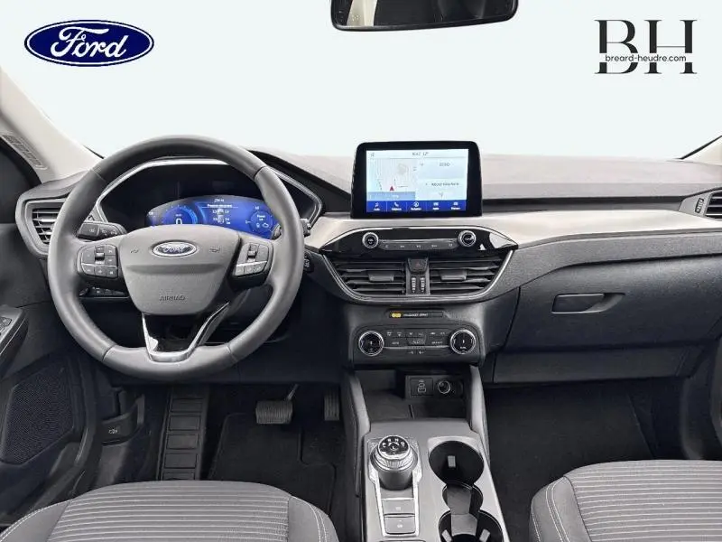 Vue frontale de l'habitacle du Ford Kuga 2023 avec volant cuir multifonction et écran tactile central.