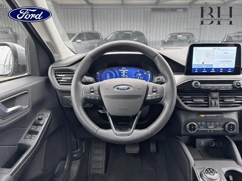 Vue intérieure centrée sur le volant cuir multifonction et l’écran tactile du Ford Kuga 2023 gris Solar Métallisée.