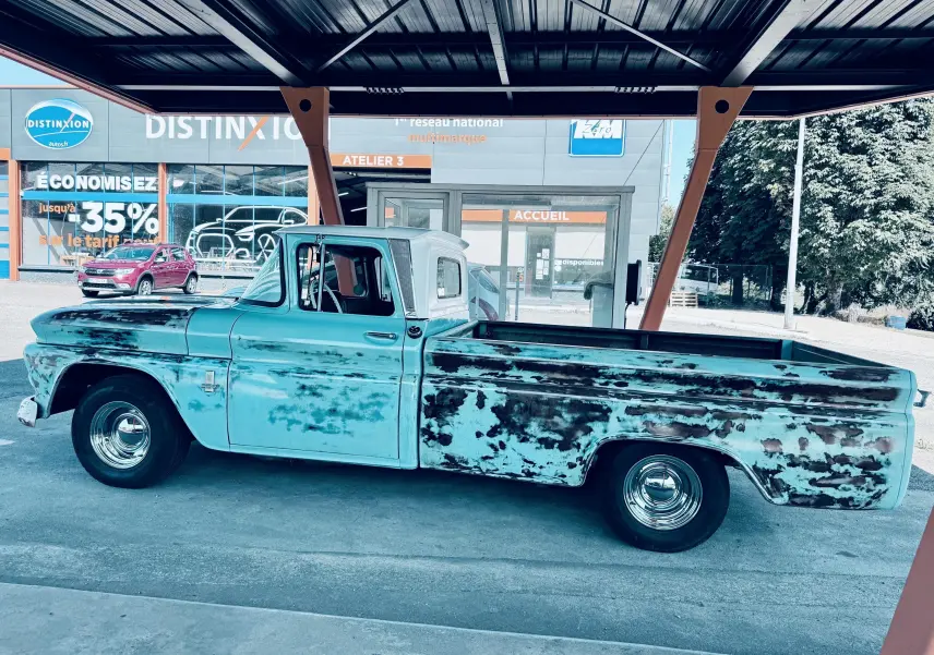 Vue de profil côté gauche d’un Chevrolet C10 Apache 1963 bleu patiné avec carrosserie vieillie et roues chromées.