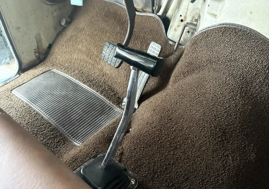 Gros plan sur le levier de vitesses automatique et les pédales dans l’habitacle beige d’un Chevrolet C10 Apache 1963.