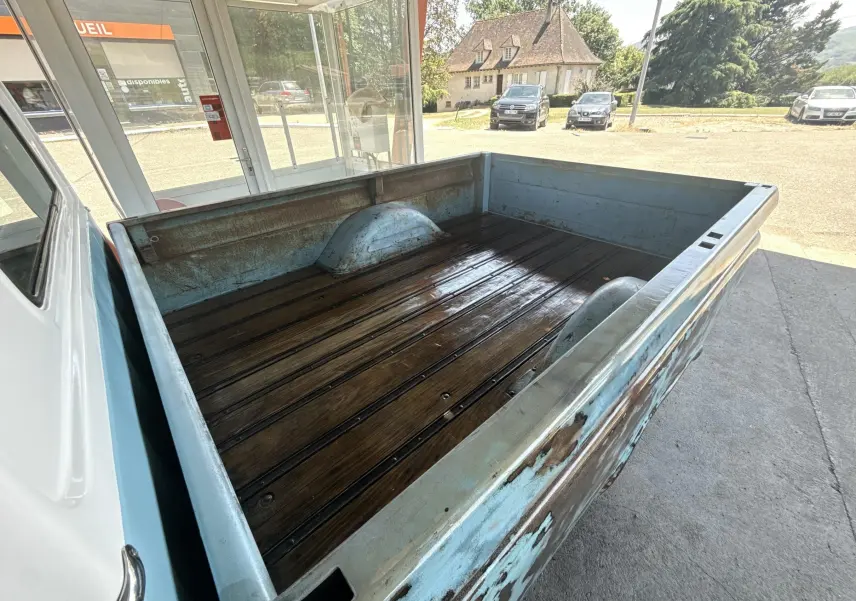 Vue arrière en 3/4 du plateau bois et métal bleu patiné du Chevrolet C10 Apache 1963, montrant l'état vintage.