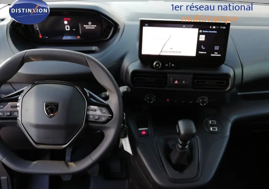 Vue intérieure centrée sur le volant et la console centrale du Peugeot Partner blanc Kaolin avec écran tactile et boîte manuelle.