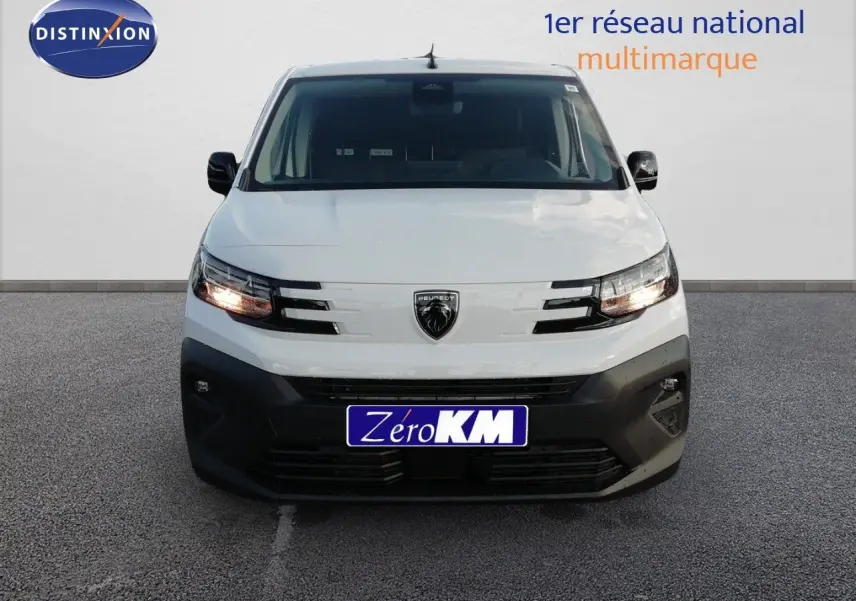 Vue frontale d'un Peugeot Partner blanc Kaolin avec calandre noire et phares allumés sur fond neutre.