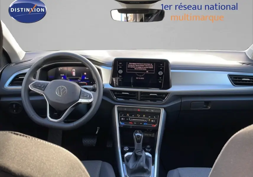 Vue intérieure avant du Volkswagen T-Roc 2025, montrant le tableau de bord moderne avec écran tactile et volant multifonction.