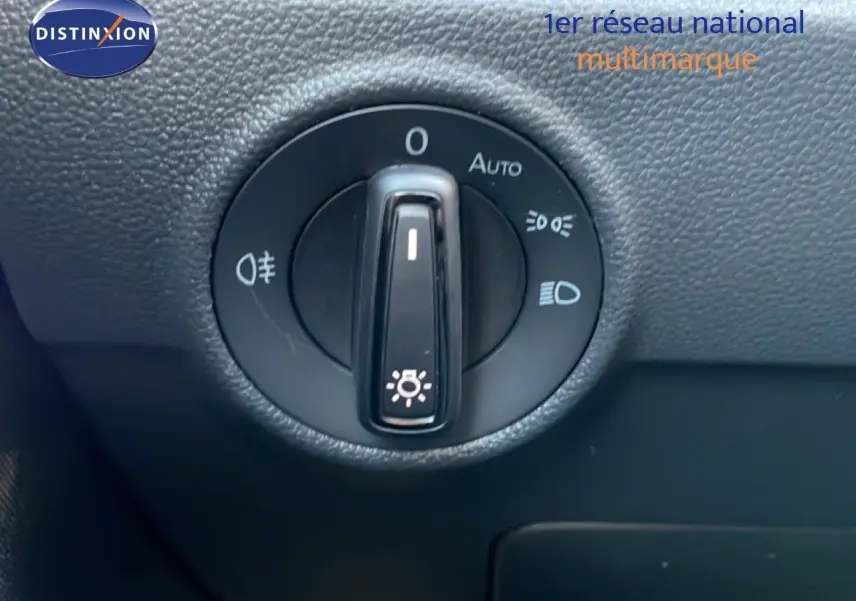 Gros plan sur la molette de commande des phares du Volkswagen T-Roc 2025 en intérieur noir texturé.