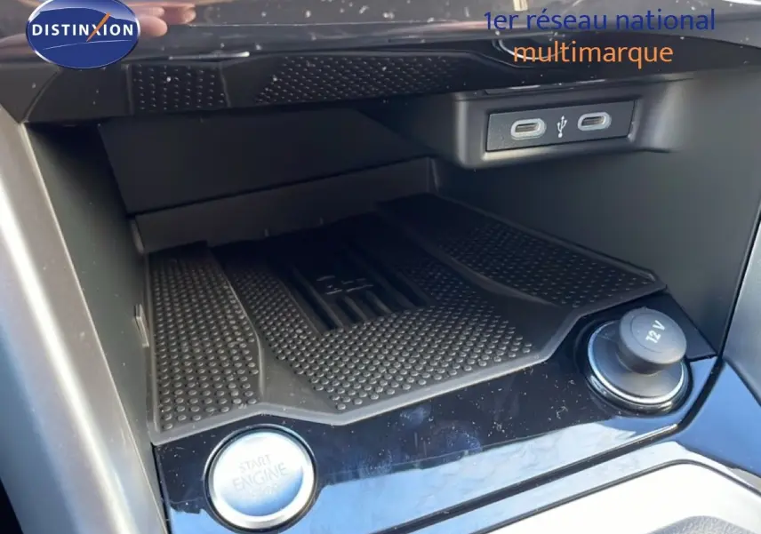 Gros plan sur la console centrale du Volkswagen T-Roc 2025, montrant le bouton start/stop, prise 12V et ports USB.