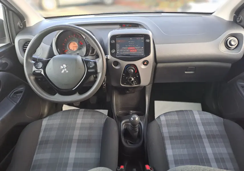 Intérieur noir de la Peugeot 108 2020, vue frontale du tableau de bord avec volant et console centrale compacte.