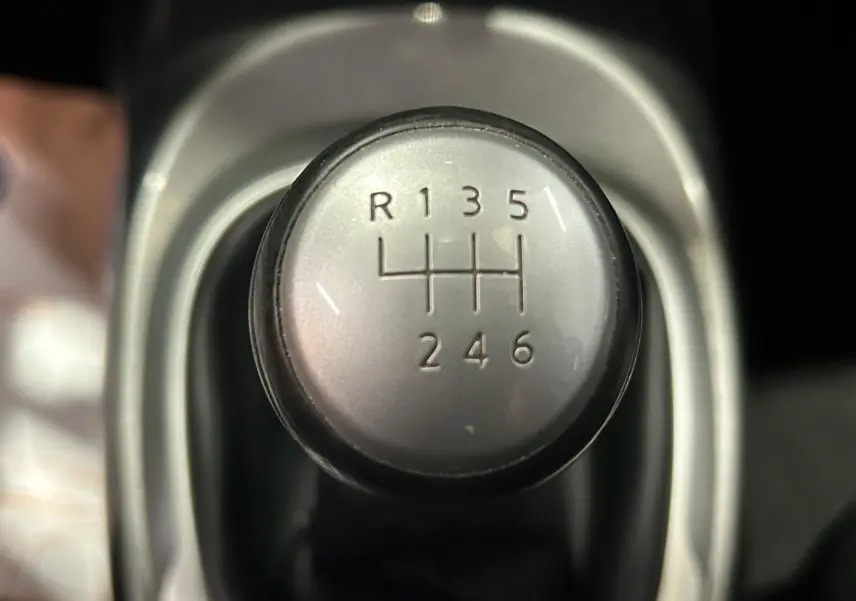 Gros plan sur le pommeau de la boîte manuelle 6 vitesses du Nissan Juke noir métal, version dci 110 Acenta avec attelage.