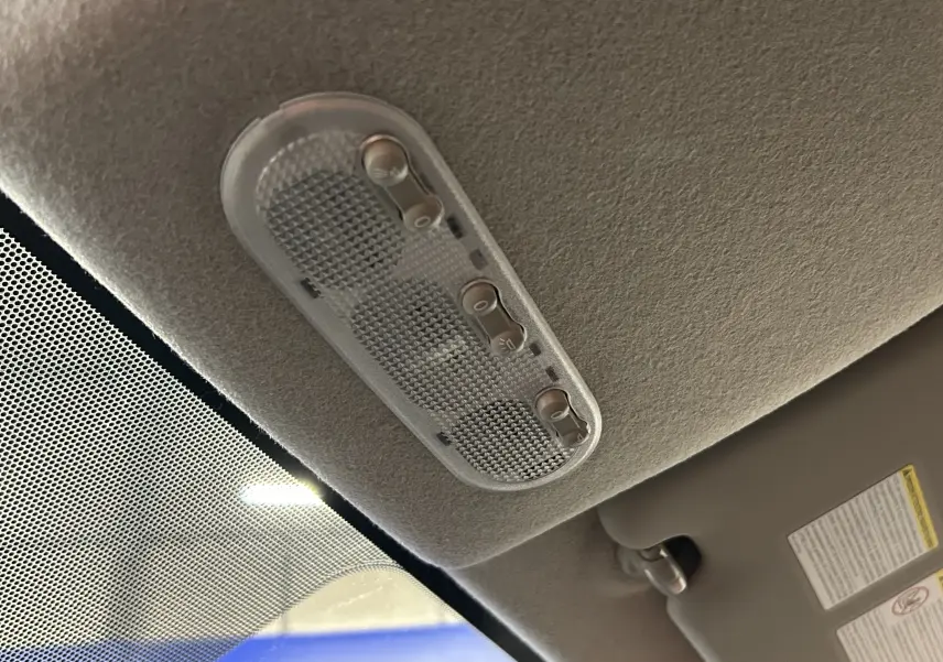 Plafonnier intérieur avec interrupteurs de lumière, vue en contre-plongée depuis l'avant du Nissan Juke.
