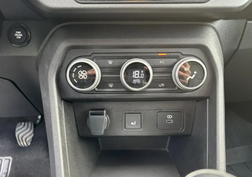 Vue rapprochée de la console centrale de la Dacia Sandero Stepway 2025, avec commandes climatisation automatique et prises USB.