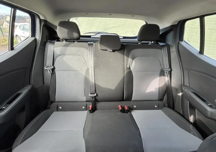 Vue arrière intérieure montrant la banquette arrière bicolore grise et noire du Dacia Sandero Stepway 2025.