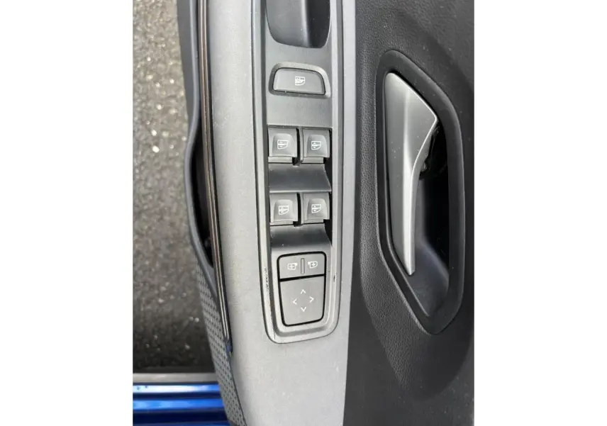 Vue rapprochée des commandes des vitres et du rétroviseur sur la porte avant gauche d'une Dacia Sandero Stepway Bleu Iron.