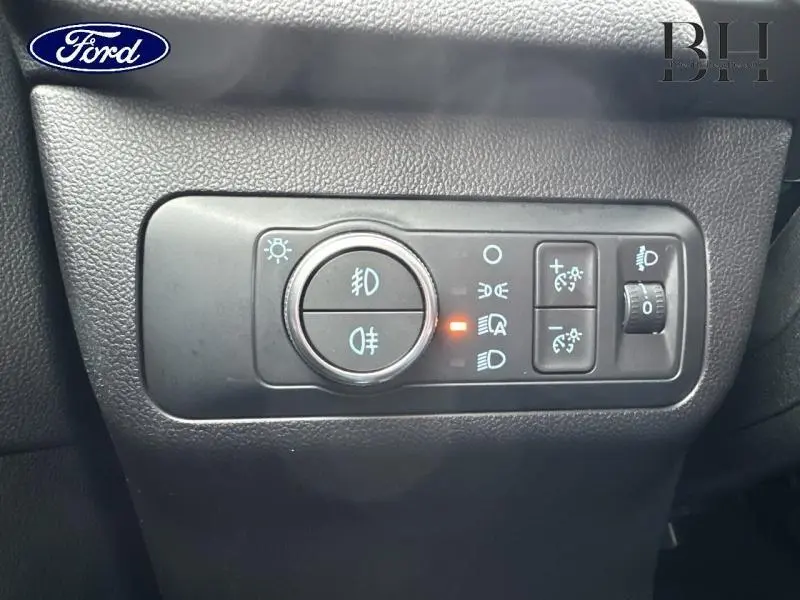 Gros plan sur les commandes d’éclairage intérieures du Ford Kuga 2022, avec indicateur lumineux orange allumé.