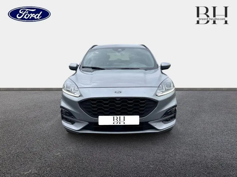 Vue frontale d'un Ford Kuga 2022 gris Solar métallisé avec calandre noire et phares LED allumés.