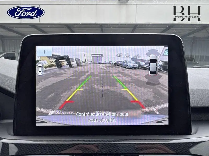 Écran tactile montrant la caméra de recul du Ford Kuga 2022 avec guidage coloré et vue arrière du véhicule.