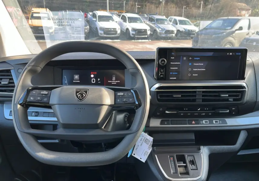 Vue intérieure frontale du tableau de bord du Peugeot Traveller 2025, avec volant multifonctions et écran tactile HD.