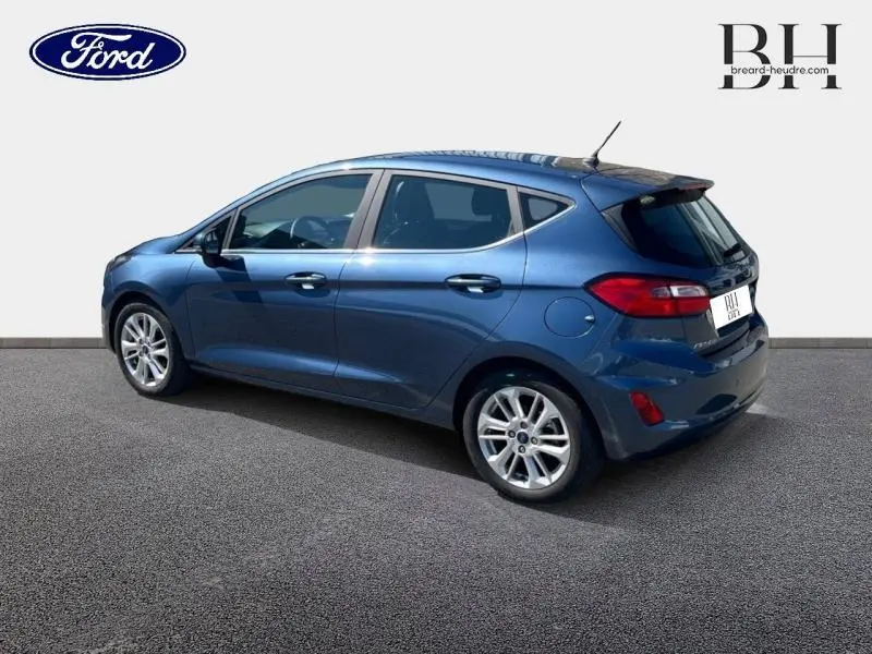 Ford Fiesta 1.0 EcoBoost Hybrid bleu azur métallisé vue 3/4 arrière droit avec jantes alu et becquet arrière.
