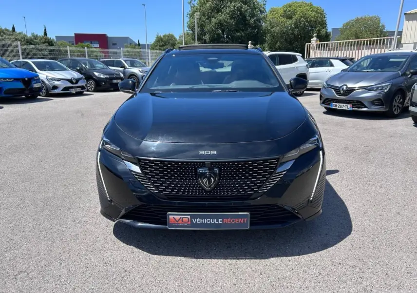 Peugeot 308 SW PHEV 225 e-EAT8 GT noir vue de face, avec calandre distinctive et barres de toit visibles.