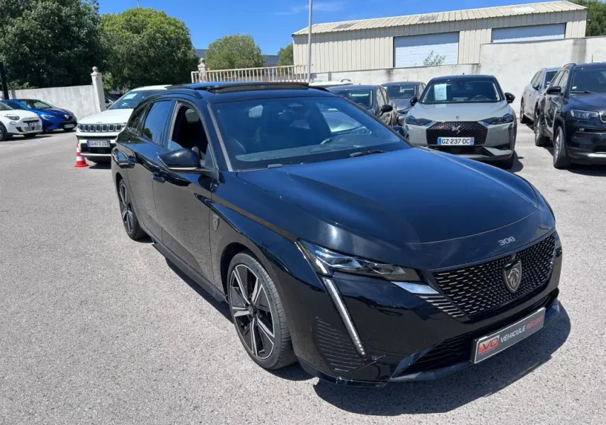 Peugeot 308 SW PHEV noir vue 3/4 avant avec jantes alliage 18 pouces et toit ouvrant électrique.