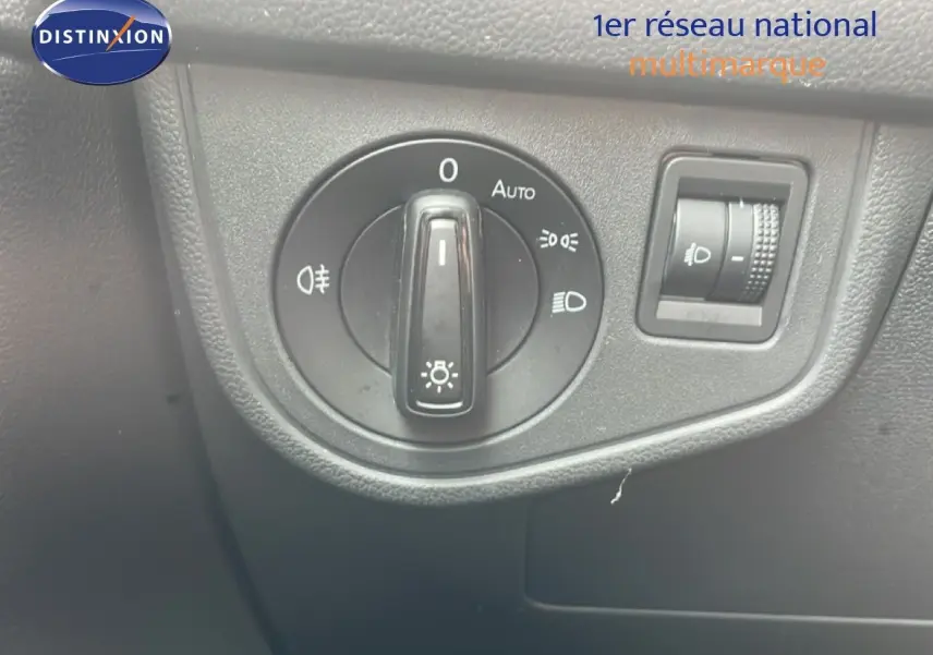 Gros plan sur le commutateur d'éclairage intérieur noir de la Volkswagen Polo blanche, avec réglage automatique et molette de réglage des phares.