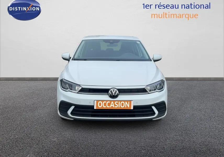 Vue frontale d'une Volkswagen Polo blanche avec plaque "OCCASION" sur fond neutre, éclairage LED visible.