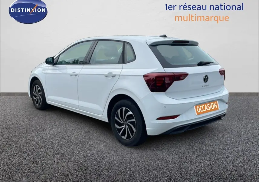 Vue 3/4 arrière droite d'une Volkswagen Polo blanche pure avec jantes bi-ton et feux arrière LED, sur fond neutre.