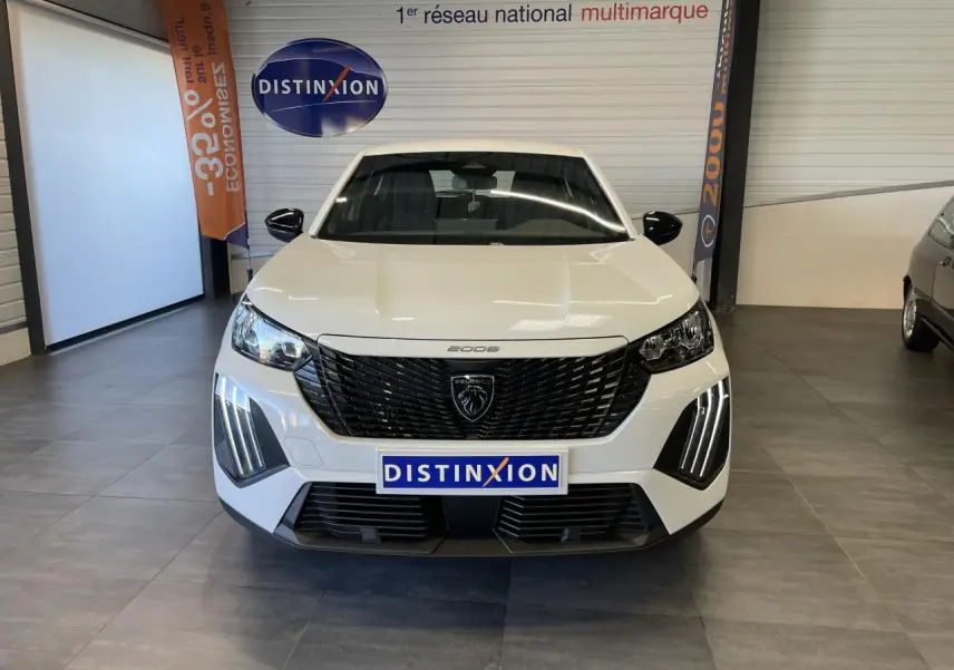 Vue avant d'un Peugeot 2008 blanc 2026 avec calandre noire et feux LED en griffes distinctifs.