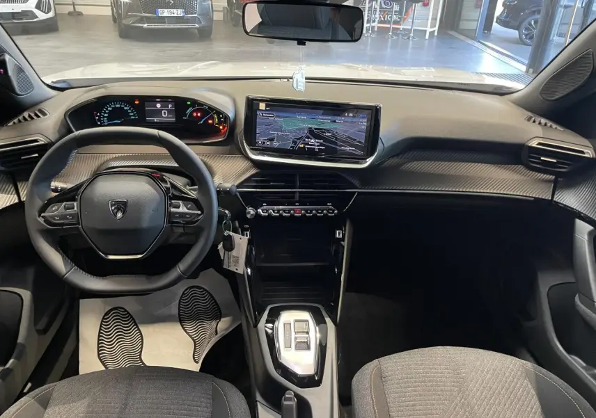 Vue intérieure avant du Peugeot 2008 blanc 2026, tableau de bord avec écran tactile 10'' et volant compact cuir noir.