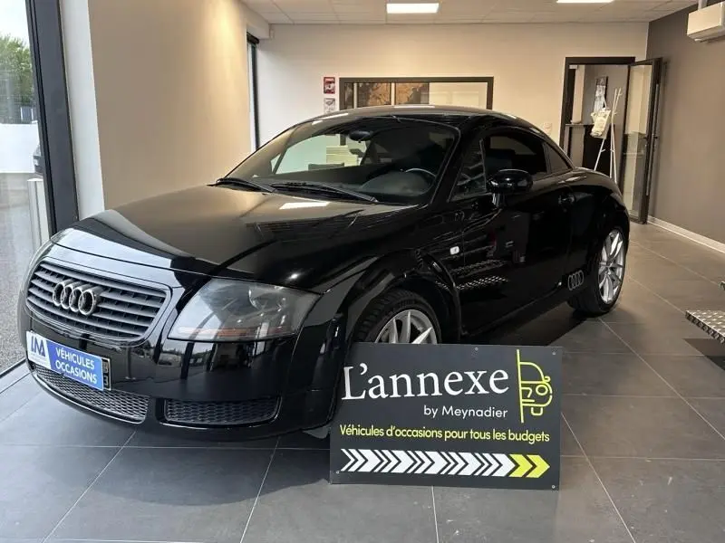 Audi TT Coupé noir de 2002 vu en 3/4 avant droit, avec jantes argentées et calandre distinctive Audi.