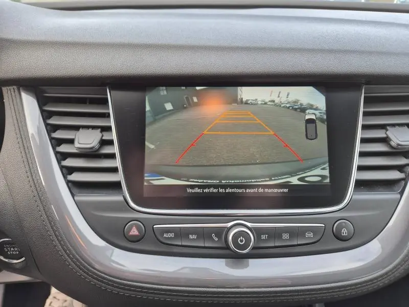 Écran tactile central montrant la caméra de recul d’un Opel Grandland X noir Diamant, avec les lignes d’aide au stationnement.
