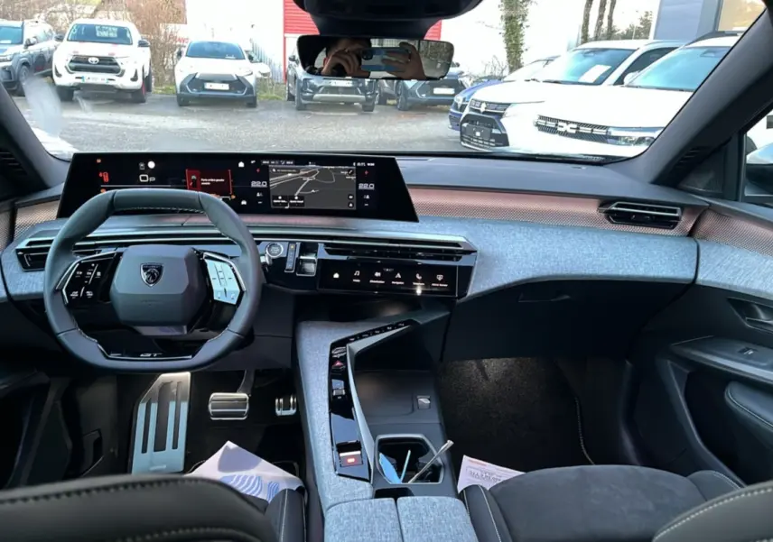 Vue intérieure avant du Peugeot 5008 Hybrid 145 GT Alcantara avec tableau de bord numérique et volant cuir multifonctions.
