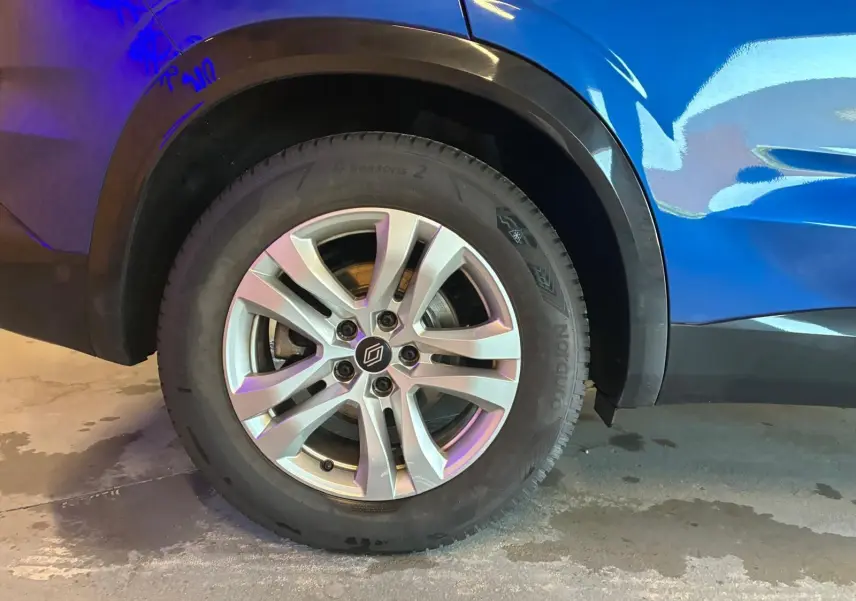 Gros plan sur la roue arrière gauche du Renault Austral bleu 2024, mettant en valeur la jante alliage et le passage de roue noir.