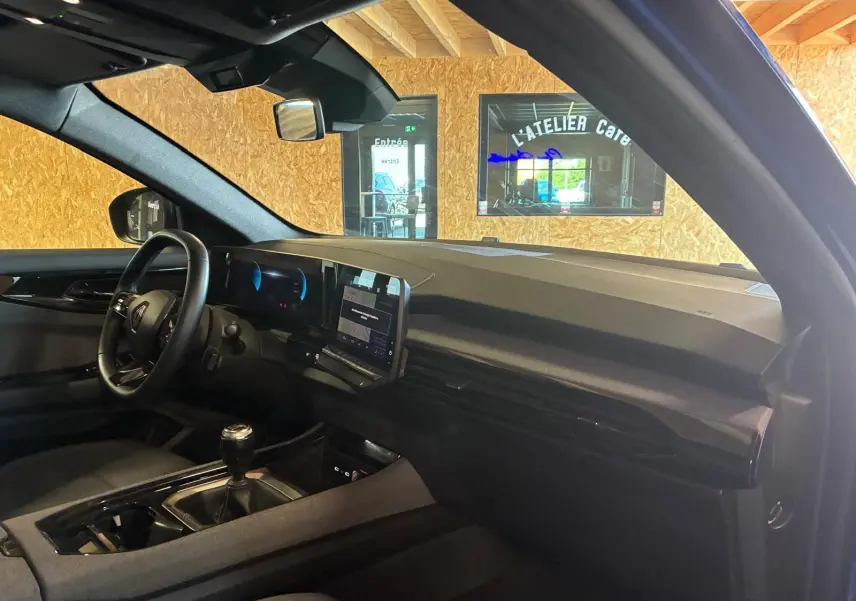 Vue intérieure côté conducteur du Renault Austral 2024, avec tableau de bord noir et écran tactile central.