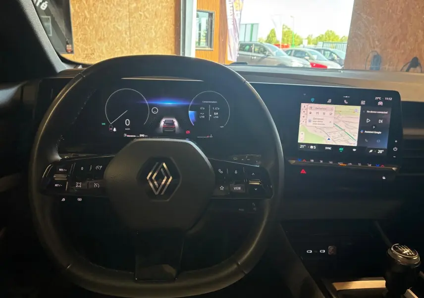 Vue intérieure centrée sur le volant noir de la Renault Austral 2024 avec tableau de bord numérique et écran tactile GPS.