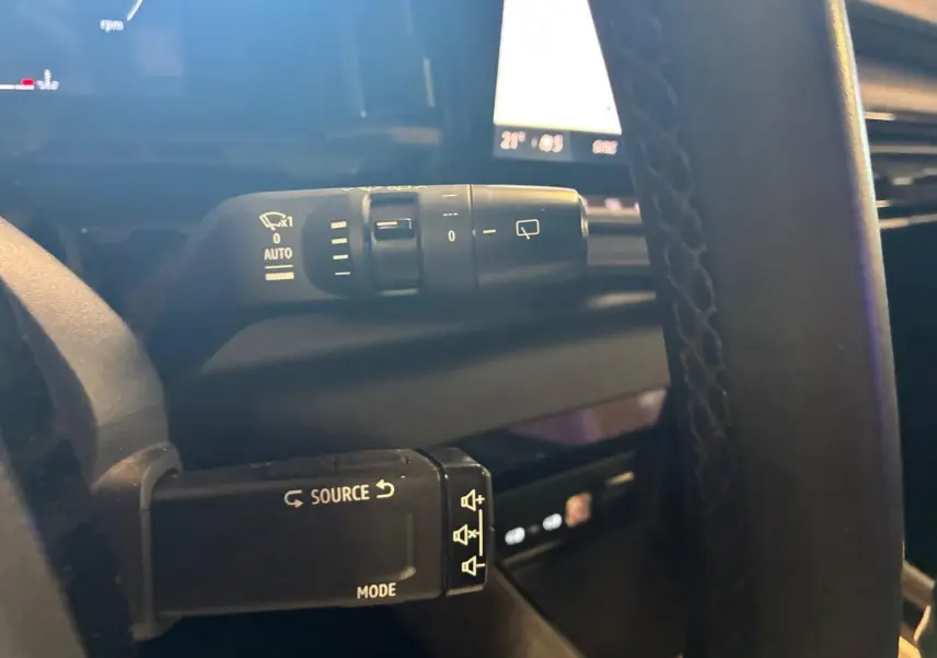 Gros plan sur les commandes au volant du Renault Austral 2024 bleu, avec réglages essuie-glace et audio visibles.