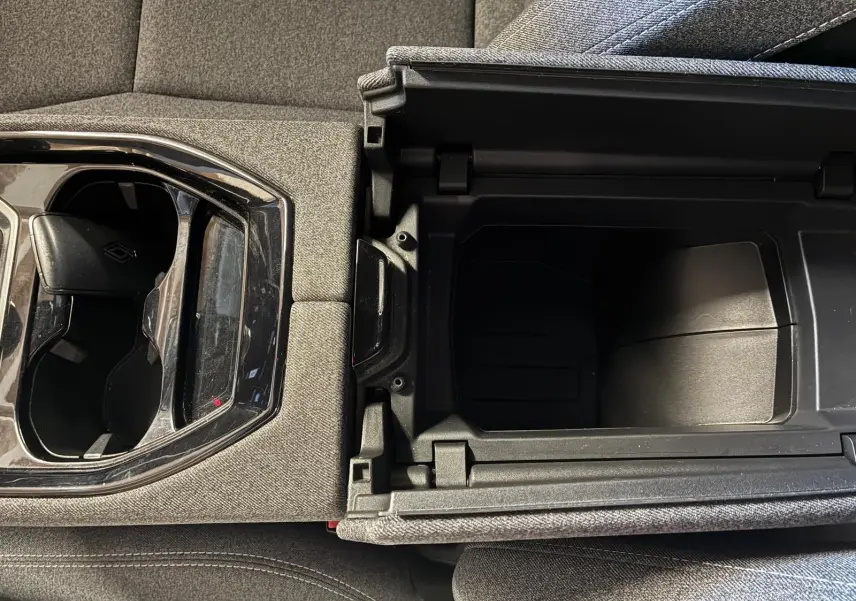 Vue en plongée sur la console centrale du Renault Austral 2024 bleu, montrant le rangement ouvert et les porte-gobelets.